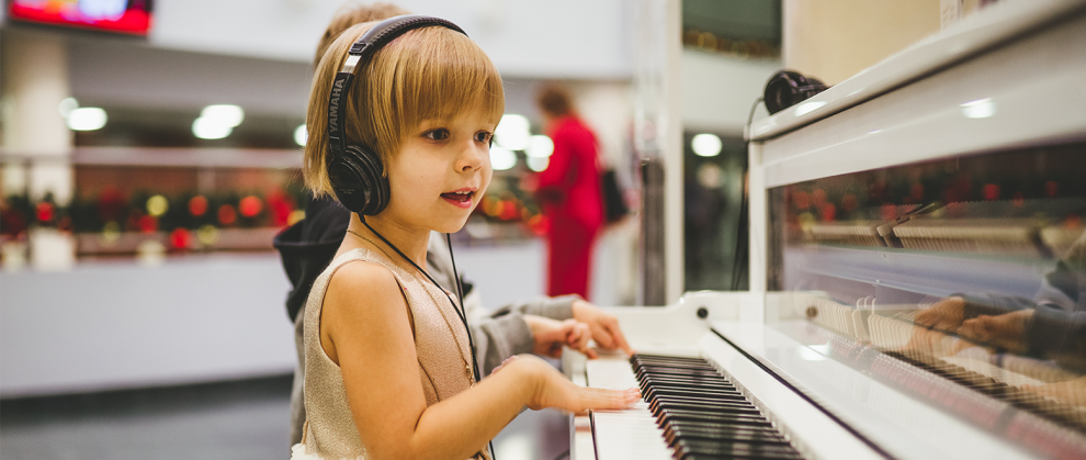 Menina ouvindo msica com fones de ouvido e tocando piano