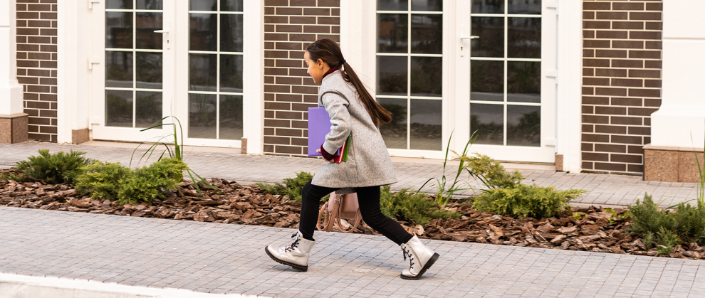 Menina voltando para escola com um caderno em sua mo
