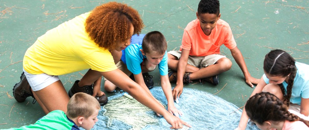 Professora com alunos em atividade ldica no cho com pintura